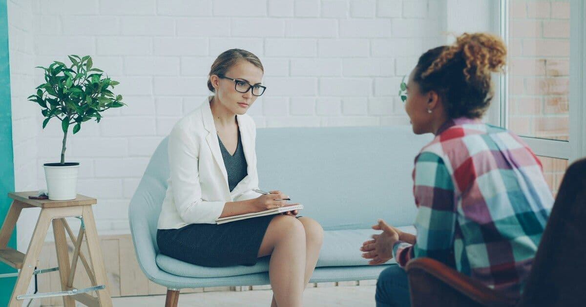 A mother receiving support from a therapist for postpartum depression