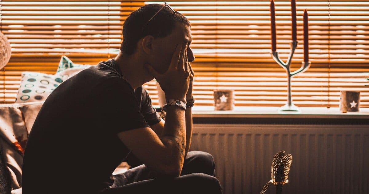 Man seated alone, deep in thought, highlighting the importance of men’s mental health