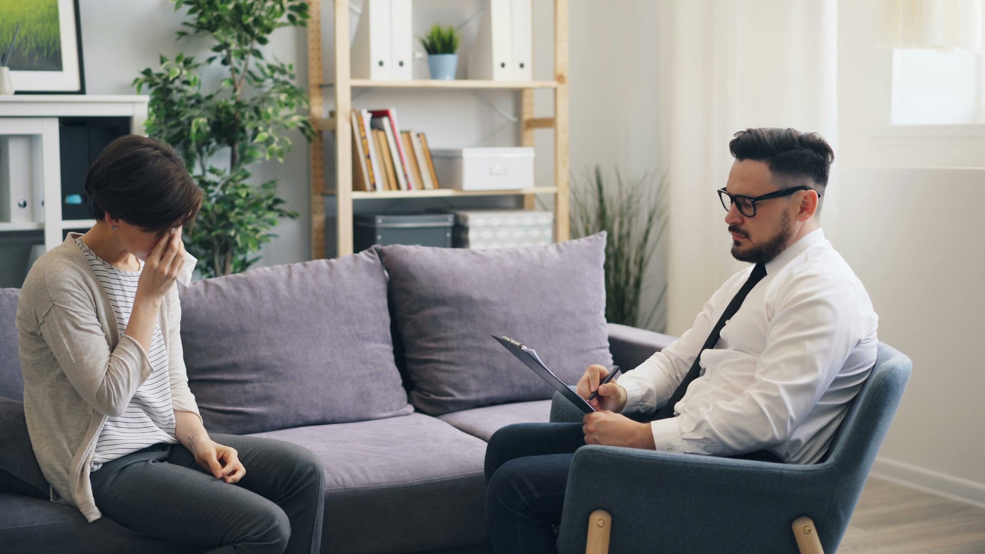 A therapist and client engaged in a counseling session, sitting together in a calm, comfortable setting.
