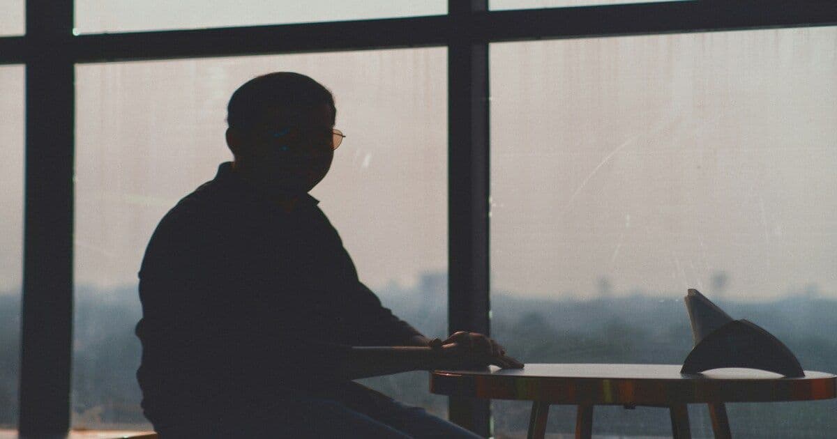 A person sitting alone indoors.